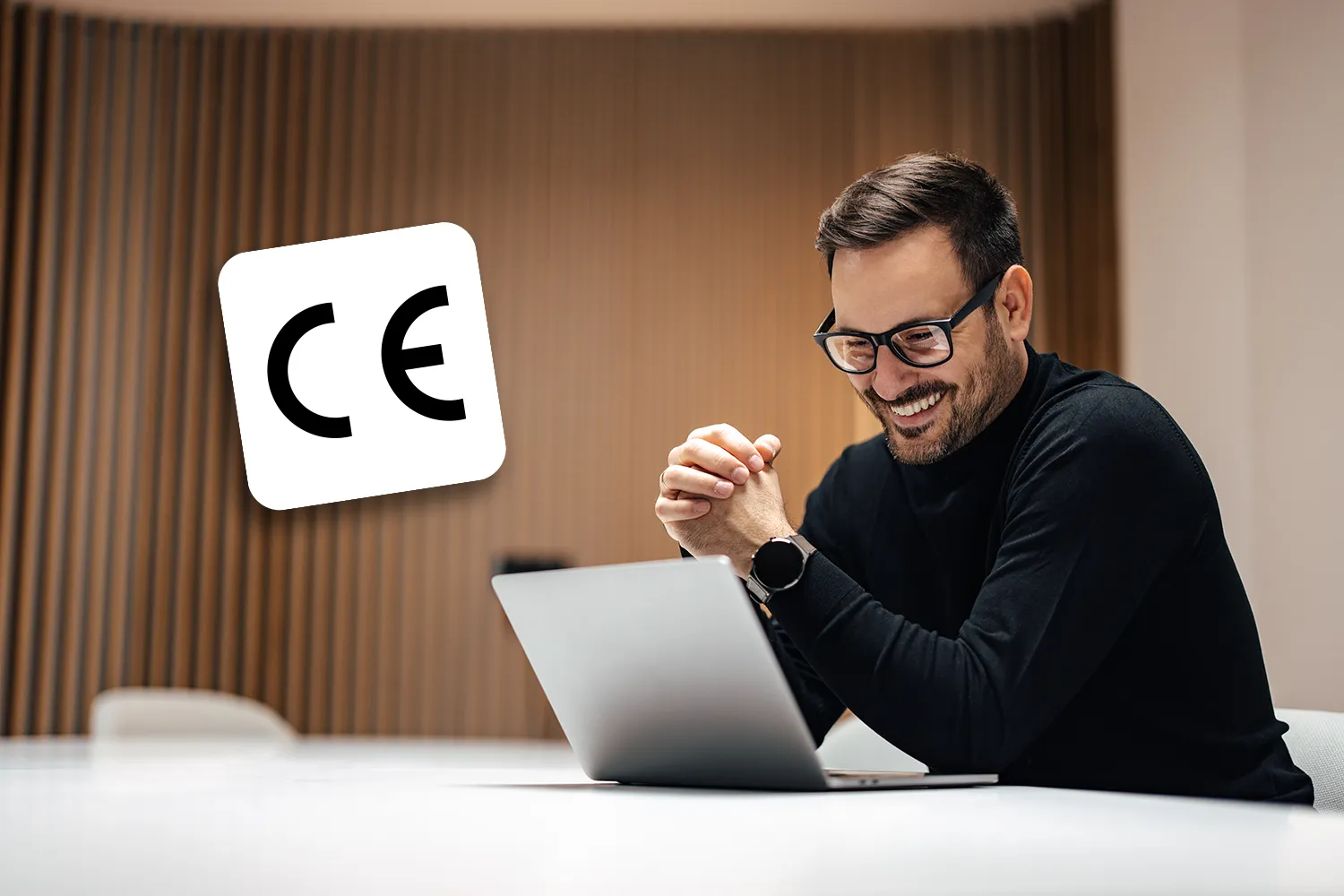 Médecin souriant devant son MacBook affichant le logiciel médical MediStory, avec la certification de conformité européenne de Prokov Éditions flottant à ses côtés.